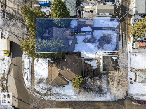Aerial view of the property and its surrounding area, featuring a brown shingled roof and mature trees - 12942 68 Street, Edmonton, AB 