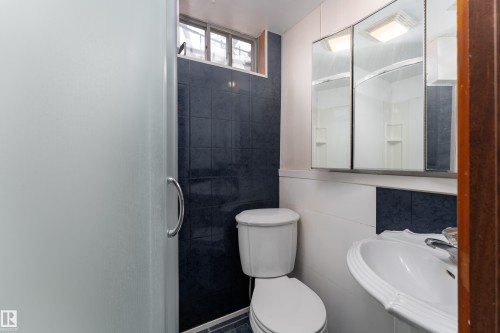Bathroom featuring a white toilet, pedestal sink, and mirrored medicine cabinet - 3711 118 Street, Edmonton, AB - Indoor Photo Showing Bathroom