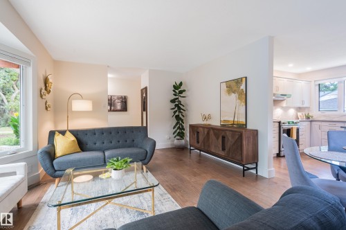 Spacious living area featuring large windows, wood-finish flooring, and a recessed wall niche - 14604 92A Avenue, Edmonton, AB - Indoor Photo Showing Living Room