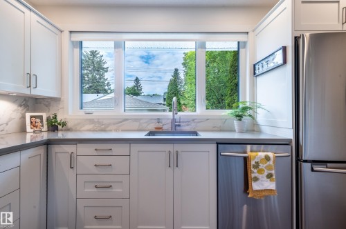 Modern kitchen with light cabinetry and a large window above the sink - 14604 92A Avenue, Edmonton, AB - Indoor Photo Showing Kitchen