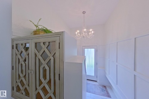 Entryway featuring wainscoting, a crystal chandelier, and a frosted glass door - 14604 92A Avenue, Edmonton, AB - Indoor Photo Showing Other Room