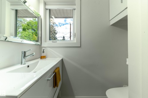 White bathroom vanity with an integrated sink and chrome faucet - 14604 92A Avenue, Edmonton, AB - Indoor Photo Showing Bathroom