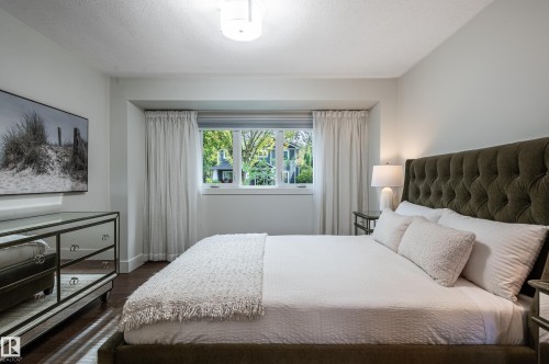 Well-appointed bedroom featuring dark wood-finish flooring, a contemporary ceiling light fixture, and white trim molding - 14604 92A Avenue, Edmonton, AB - Indoor Photo Showing Bedroom