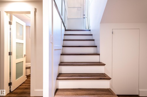 Hardwood tread staircase with white risers and a white painted wall - 14604 92A Avenue, Edmonton, AB - Indoor Photo Showing Other Room