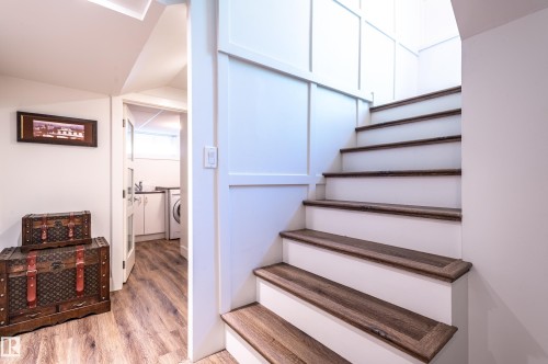 Staircase featuring wood-finish treads and white risers with board and batten paneling - 14604 92A Avenue, Edmonton, AB - Indoor Photo Showing Other Room