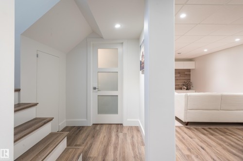Wood-finish flooring throughout, complemented by recessed lighting and white trim - 14604 92A Avenue, Edmonton, AB - Indoor Photo Showing Other Room
