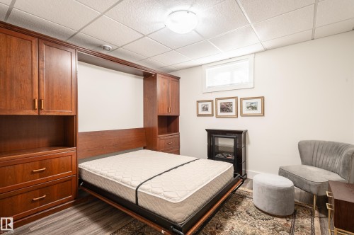 Integrated wall bed system featuring warm wood-finish cabinetry, drawers, and shelving - 14604 92A Avenue, Edmonton, AB - Indoor Photo Showing Bedroom