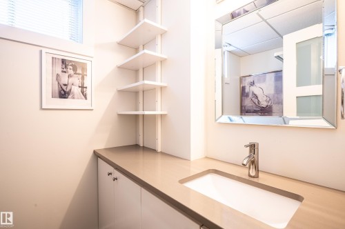 Integrated vanity with a rectangular undermount sink, a chrome single-handle faucet, and a light-toned countertop - 14604 92A Avenue, Edmonton, AB - Indoor Photo Showing Bathroom