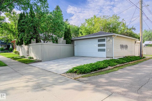 Detached garage with horizontal siding and a modern panel door featuring frosted glass inserts - 14604 92A Avenue, Edmonton, AB - Outdoor