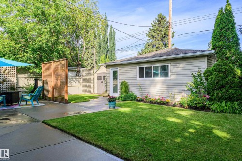 Spacious backyard featuring a large concrete patio, a manicured lawn, and mature trees - 14604 92A Avenue, Edmonton, AB - Outdoor
