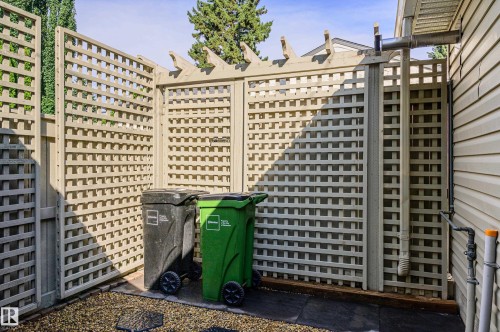 Side yard featuring light-toned lattice fencing, a gravel surface, and vinyl siding - 14604 92A Avenue, Edmonton, AB - Outdoor With Facade