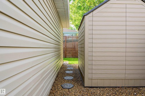 Side yard featuring gravel ground cover, stepping stones, and a storage shed with horizontal siding - 14604 92A Avenue, Edmonton, AB - Outdoor With Exterior