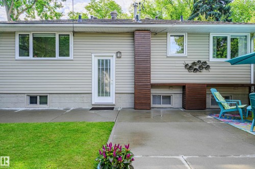 Rear exterior featuring light-toned horizontal siding and a full-light panel door - 14604 92A Avenue, Edmonton, AB - Outdoor With Exterior