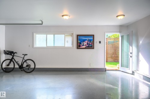 Spacious garage featuring a durable epoxy floor, white walls, and bright overhead lighting - 14604 92A Avenue, Edmonton, AB - Indoor Photo Showing Other Room