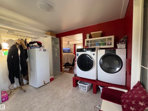 laundry area featuring a washer and dryer, patterned flooring, and a window for natural light. Located in front entry. - 115 2Nd Street E, Derwent, AB - Indoor Photo Showing Laundry Room
