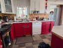 Kitchen featuring red lower cabinetry and white upper cabinetry, a stainless steel sink, a built-in dishwasher, and a tile floor. - 115 2Nd Street E, Derwent, AB  - Indoor Photo Showing Kitchen With Double Sink 