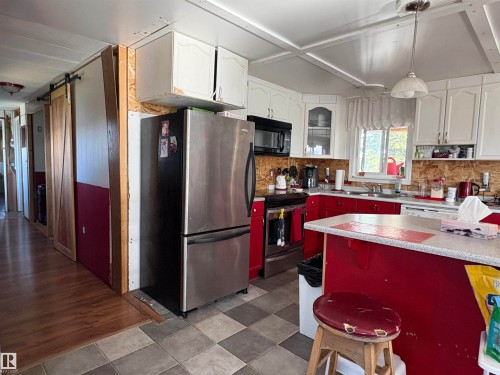 Kitchen featuring checkered tile flooring, white upper cabinetry, and red lower cabinetry. - 115 2Nd Street E, Derwent, AB - Indoor Photo Showing Kitchen With Double Sink