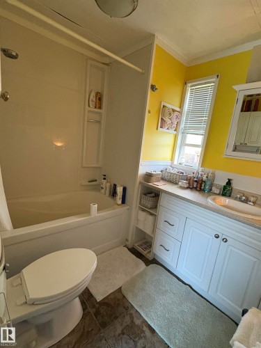 Bathroom featuring a white vanity with integrated sink, white base cabinets, and built-in shelving - 115 2Nd Street E, Derwent, AB - Indoor Photo Showing Bathroom