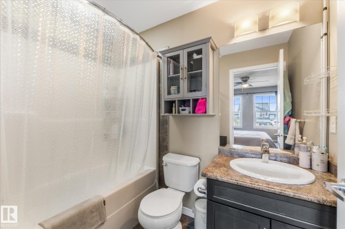 Bathroom featuring a vanity with a counter-mounted sink, a dark wood-finish cabinet, and a wall-mounted mirror with overhead lighting - 21818 99A Avenue, Edmonton, AB - Indoor Photo Showing Bathroom