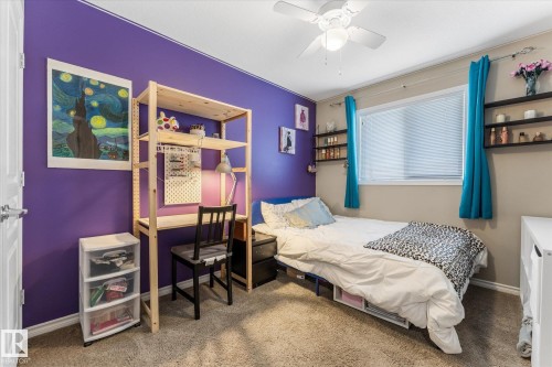 Bedroom featuring a ceiling fan with integrated lighting, a window with horizontal blinds, and wall-mounted shelving - 21818 99A Avenue, Edmonton, AB - Indoor Photo Showing Bedroom