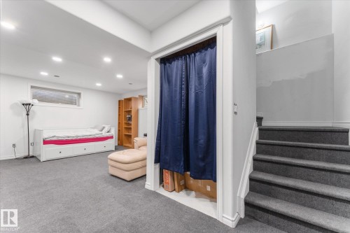 Carpeted lower-level room featuring a window with blinds, recessed lighting, and a carpeted staircase with white trim - 21818 99A Avenue, Edmonton, AB - Indoor Photo Showing Other Room