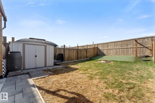 Fenced backyard featuring a paver patio, storage shed, and a dedicated artificial turf area - 21818 99A Avenue, Edmonton, AB - Outdoor
