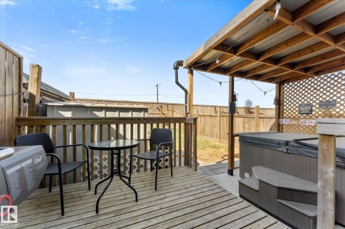 Expansive wood deck with a built-in hot tub featuring a protective cover and access steps - 21818 99A Avenue, Edmonton, AB - Outdoor With Deck Patio Veranda With Exterior