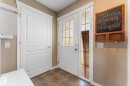 Entryway with brown-toned tile flooring, a white front door featuring glass paneling, and an adjacent white interior door with decorative paneling - 21818 99A Avenue, Edmonton, AB  - Indoor Photo Showing Other Room 