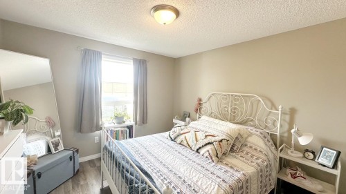 This room features a window with curtains, wood-style flooring, and a ceiling light fixture - 1112 9363 Simpson Drive, Edmonton, AB - Indoor Photo Showing Bedroom