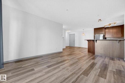 Open concept living area with plank wood-finish flooring - 215 2208 44 Avenue, Edmonton, AB - Indoor Photo Showing Kitchen
