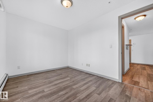 Room featuring wood-finish flooring, white walls, and a semi-flush ceiling light - 215 2208 44 Avenue, Edmonton, AB - Indoor Photo Showing Other Room