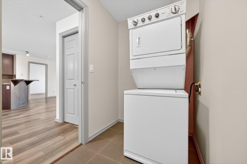 Dedicated laundry area featuring a stacked washer and dryer unit - 215 2208 44 Avenue, Edmonton, AB - Indoor Photo Showing Laundry Room