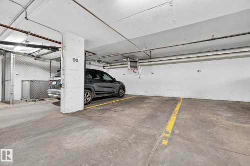 Dedicated underground parking space with concrete flooring and overhead lighting - 215 2208 44 Avenue, Edmonton, AB - Indoor Photo Showing Garage