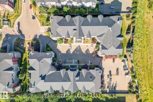 Overhead view of a multi-building complex featuring dark gray shingle roofs, multiple paved parking areas, and mature landscaping - 215 2208 44 Avenue, Edmonton, AB - Outdoor With View
