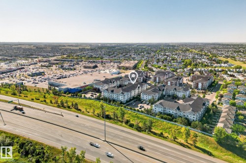 Aerial perspective showcasing a residential development with multiple low-rise buildings featuring dark roofs and light-colored siding - 215 2208 44 Avenue, Edmonton, AB - Outdoor With View