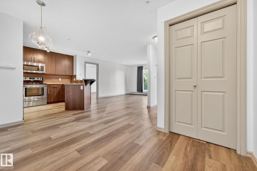 Open-concept living area with wood-finish flooring extending throughout - 215 2208 44 Avenue, Edmonton, AB - Indoor Photo Showing Kitchen