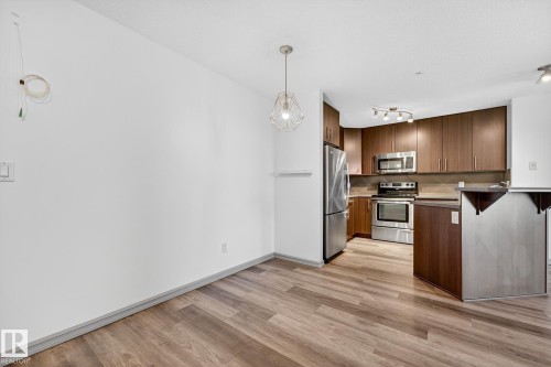 Open-concept living space featuring wood-finish flooring throughout - 215 2208 44 Avenue, Edmonton, AB - Indoor Photo Showing Kitchen