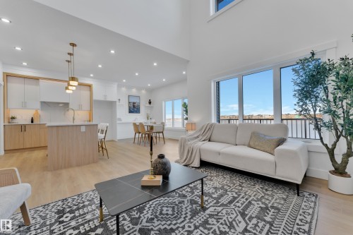 Open-concept living space featuring high ceilings, light wood-finish flooring, and large windows - 382 Linden Loop, Leduc, AB - Indoor Photo Showing Living Room