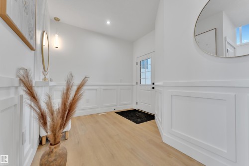 Entryway featuring light wood-finish flooring, white paneled wainscoting, recessed lighting, and a modern pendant light fixture - 382 Linden Loop, Leduc, AB - Indoor Photo Showing Other Room