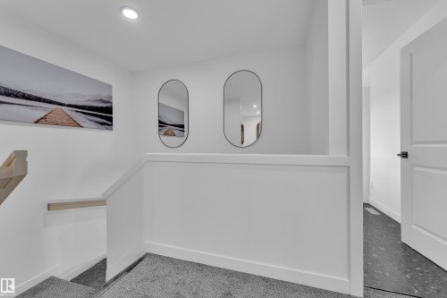 Staircase featuring light gray carpeted treads and a light wood handrail - 259 Linden Loop, Leduc, AB - Indoor
