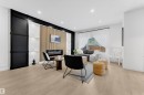 Spacious living area featuring light wood-finish flooring, recessed lighting, and a prominent accent wall with a built-in electric fireplace - 259 Linden Loop, Leduc, AB  - Indoor 