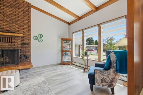 Vaulted ceiling with exposed wood beams - 8608 22 Ave, Edmonton, AB - Indoor Photo Showing Living Room With Fireplace