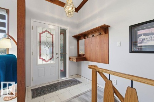 Entryway featuring a white door with decorative glass inserts, a matching sidelight, and white tile flooring - 8608 22 Ave, Edmonton, AB - Indoor Photo Showing Other Room