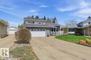 Two-story property featuring a gray exterior finish, an attached two-car garage, and a long concrete driveway - 8608 22 Ave, Edmonton, AB  - Outdoor With Facade 