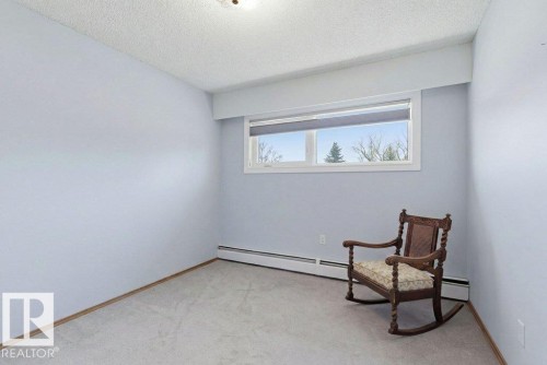 Room featuring light blue walls, a white window frame, and neutral carpeting - 8608 22 Ave, Edmonton, AB - Indoor Photo Showing Other Room