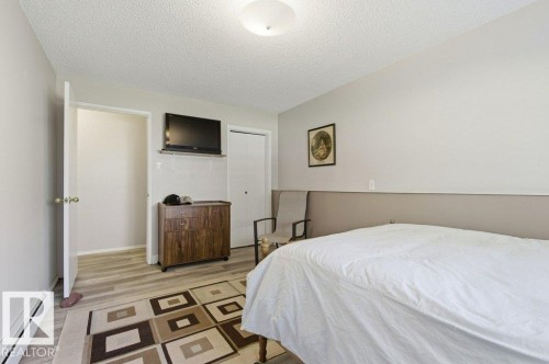 Room featuring wood-finish flooring, light neutral wall paint, and a textured ceiling - 8608 22 Ave, Edmonton, AB - Indoor Photo Showing Bedroom