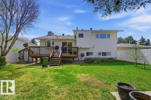 Expansive backyard featuring a large wood deck with stairs, white siding, multiple windows, and a detached storage shed - 8608 22 Ave, Edmonton, AB - Outdoor