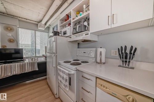 Compact kitchen featuring white cabinetry, white countertop surfaces, and a white electric range - 1207 10024 Jasper Avenue, Edmonton, AB - Indoor Photo Showing Kitchen