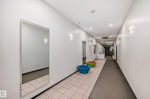 Long corridor featuring a full-length wall mirror, white painted walls, and recessed lighting - 1207 10024 Jasper Avenue, Edmonton, AB - Indoor Photo Showing Other Room