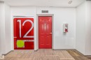 Hallway featuring a paneled red entry door, fire extinguisher cabinet, and patterned carpet flooring - 1207 10024 Jasper Avenue, Edmonton, AB  - Indoor Photo Showing Other Room 